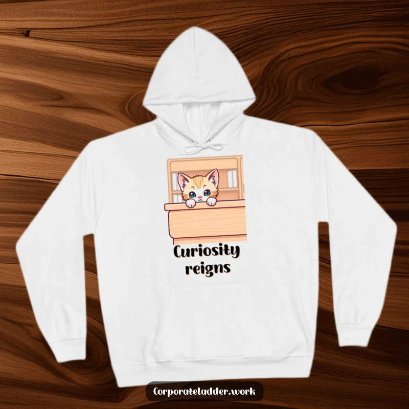 Funny kitten peeking over a large desk, depicted on a cozy hoodie, embodying playful comfort and charm.
